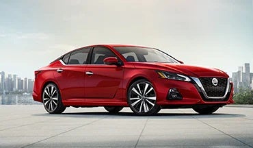 2023 Nissan Altima in red with city in background illustrating last year's 2022 model in Mathews Nissan in Paris TX