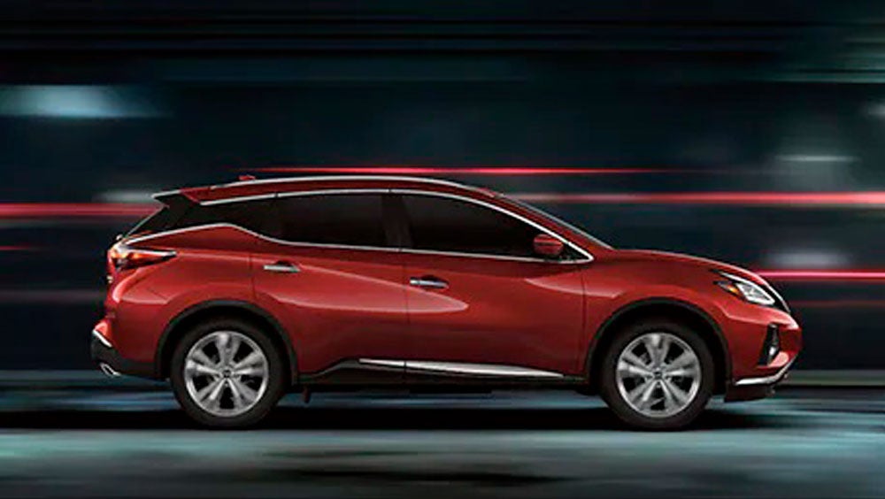 2023 Nissan Murano shown in profile driving down a street at night illustrating performance. | Mathews Nissan in Paris TX
